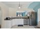 Bright kitchen featuring granite counters, white cabinets, and stainless steel appliances at 149 Angeles Rd, Debary, FL 32713