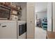 Efficient laundry area with modern washer and dryer, and overhead shelving for organized storage solutions at 149 Angeles Rd, Debary, FL 32713
