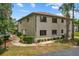 Exterior corner view of a multi-story home with neutral tones, landscaping, and manicured shrubs at 1601 Big Tree Rd # 1301, South Daytona, FL 32119
