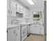 White kitchen featuring white cabinets, white appliances and tile backsplash at 1601 Big Tree Rd # 1301, South Daytona, FL 32119