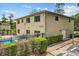 Exterior of a two-story condo building featuring a pool, black fence, and well-maintained landscaping at 1601 Big Tree Rd # 1302, South Daytona, FL 32119