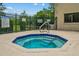 Community hot tub featuring blue-tiled steps and a metal railing, surrounded by a black fence at 1601 Big Tree Rd # 1302, South Daytona, FL 32119