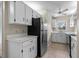 Well lit kitchen featuring white cabinetry, stainless-steel refrigerator, and a ceiling fan at 1601 Big Tree Rd # 1302, South Daytona, FL 32119