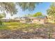Back exterior view of this charming home with large windows, a patio, and a lush green lawn at 1617 Tuscaloosa Ave, Daytona Beach, FL 32117