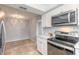 Updated kitchen showcasing stainless steel appliances, white cabinets, and tile flooring for a modern and clean aesthetic at 1617 Tuscaloosa Ave, Daytona Beach, FL 32117