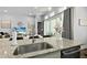 Modern kitchen boasts granite countertops, stainless sink, and open design to the living area at 165 Azure Mist Way, Daytona Beach, FL 32124