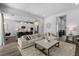 Open-concept living space with a sectional sofa, kitchen island with bar seating, and sleek modern finishes at 165 Azure Mist Way, Daytona Beach, FL 32124