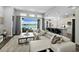 Bright and airy living room featuring a white sofa, stylish decor, and expansive windows overlooking the pool and lake at 165 Azure Mist Way, Daytona Beach, FL 32124