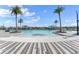 Beautiful community pool with shallow wading area, tropical landscaping, and blue skies at 165 Azure Mist Way, Daytona Beach, FL 32124