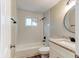 A bathroom with white tiled tub and shower combo and a granite countertop vanity at 165 S Massachusetts Ave, Deland, FL 32724