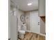Bright bathroom featuring a shower, toilet, vanity with a round mirror and wooden floors at 165 S Massachusetts Ave, Deland, FL 32724