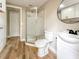 Bathroom featuring a glass shower, toilet, vanity with a round mirror and wooden floors at 165 S Massachusetts Ave, Deland, FL 32724