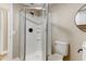 Bathroom featuring a glass shower, toilet, vanity with a round mirror and black hardware at 165 S Massachusetts Ave, Deland, FL 32724