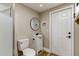 Bathroom featuring a shower, toilet, vanity with a round mirror and wooden floors at 165 S Massachusetts Ave, Deland, FL 32724