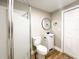 Bright bathroom featuring a shower, toilet, vanity with a round mirror and wooden floors at 165 S Massachusetts Ave, Deland, FL 32724