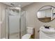 Bathroom featuring a glass shower, toilet, vanity with a round mirror and cabinets above at 165 S Massachusetts Ave, Deland, FL 32724