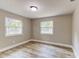 A bright bedroom offering two windows and modern, light-wood floors at 165 S Massachusetts Ave, Deland, FL 32724