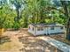 Exterior view of a charming single-story home with a well-kept lawn and mature trees at 165 S Massachusetts Ave, Deland, FL 32724