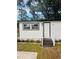 Close-up of a home's inviting front door, showcasing fresh landscaping and a welcoming entrance at 165 S Massachusetts Ave, Deland, FL 32724