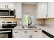 Bright kitchen features white cabinets, granite countertops, and stainless steel appliances at 165 S Massachusetts Ave, Deland, FL 32724