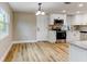 Open kitchen with hardwood floors, stainless steel appliances, granite countertops, and white cabinets at 165 S Massachusetts Ave, Deland, FL 32724