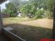 View of the chain link fenced in backyard with shed, playset and mature trees at 1714 Urbana Ave, Deltona, FL 32725