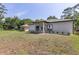 Backyard view featuring a grass lawn and home exterior with a covered patio at 1738 Palm Rd, Ormond Beach, FL 32174