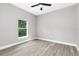 Bedroom featuring neutral gray walls, ceiling fan, and a window with natural lighting at 1738 Palm Rd, Ormond Beach, FL 32174
