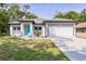 Inviting home exterior with a bright turquoise front door and attached two-car garage at 1738 Palm Rd, Ormond Beach, FL 32174