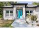 Close-up of a modern home's entrance, featuring a vibrant turquoise door and decorative landscaping at 1738 Palm Rd, Ormond Beach, FL 32174