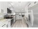 Modern kitchen with white cabinets, stainless steel appliances, and an open design to the living area at 1738 Palm Rd, Ormond Beach, FL 32174