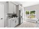 Updated kitchen featuring gray cabinets, stainless steel refrigerator, and a bright window view at 1738 Palm Rd, Ormond Beach, FL 32174
