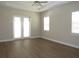 Spacious bedroom with double doors and wood-style flooring at 1870 Pepper Tree Ln, Deland, FL 32720