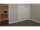 Bedroom with vinyl floors features a closet and view of living room fireplace at 1870 Pepper Tree Ln, Deland, FL 32720