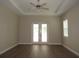 Spacious bedroom with ceiling fan, wood-style floors, and double doors at 1870 Pepper Tree Ln, Deland, FL 32720