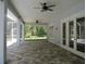 Covered patio with stone flooring and ceiling fans, ideal for relaxing and entertaining, with backyard views at 1870 Pepper Tree Ln, Deland, FL 32720