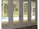 This screened-in patio shows an inviting view of the pool, yard, and trees beyond at 1870 Pepper Tree Ln, Deland, FL 32720