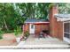 Quaint brick patio with outdoor dining set and red umbrella, creating a cozy and inviting space at 20 Monroe Ave, Debary, FL 32713