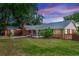 Well-maintained brick home with a spacious backyard, screened-in patio, and lush landscaping at dusk at 20 Monroe Ave, Debary, FL 32713