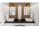 Bathroom featuring double sinks, wooden accent wall, modern lighting, and tiled floor at 20 Monroe Ave, Debary, FL 32713