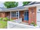 Inviting brick home with a charming blue front door, white picket fence, and well-maintained landscaping at 20 Monroe Ave, Debary, FL 32713