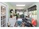 Bright sunroom with large windows, green walls, and stylish decor for relaxation and entertainment at 20 Monroe Ave, Debary, FL 32713