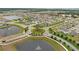 Aerial shot of a neighborhood featuring a roundabout with mature trees and water features throughout the community at 2000 White Pelican Ter, Sanford, FL 32771