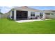 Large backyard with a well-maintained lawn, patio, and outdoor kitchen at 2000 White Pelican Ter, Sanford, FL 32771