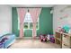 Bright bedroom featuring a window, pink curtains, and green walls at 2000 White Pelican Ter, Sanford, FL 32771