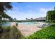 Community pool surrounded by lounge chairs, lush landscaping, and palm trees at 2000 White Pelican Ter, Sanford, FL 32771
