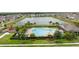 Aerial view of the community pool and clubhouse area, surrounded by lush landscaping and a serene pond at 2000 White Pelican Ter, Sanford, FL 32771