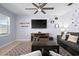 Comfortable living room with ceiling fan, media center, and large wall mounted television at 2000 White Pelican Ter, Sanford, FL 32771
