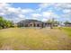 The expansive backyard featuring a screened-in pool, lush lawn, and serene landscaping at 2055 Little Farms Ct, Deltona, FL 32738