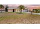 Charming brick home with a well-manicured lawn and a palm tree, located near a lake at 2055 Little Farms Ct, Deltona, FL 32738